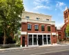 Brick facade with large-pane windows and a cream-colored upper story Brick facade with large-pane windows and a cream-colored upper story