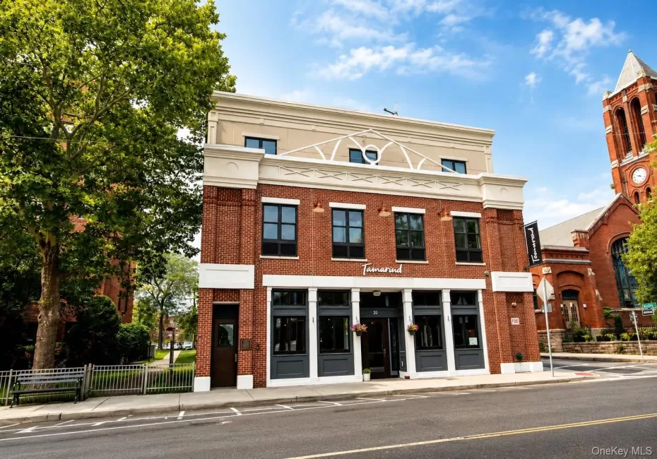 Brick facade with large-pane windows and a cream-colored upper story Brick facade with large-pane windows and a cream-colored upper story