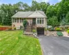 Split-level residence featuring a single-car garage, front brick steps with wrought iron railings, and a paved driveway Split-level residence featuring a single-car garage, front brick steps with wrought iron railings, and a paved driveway