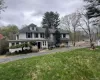 View of front of property with a front yard, driveway, an attached garage, and a chimney View of front of property with a front yard, driveway, an attached garage, and a chimney