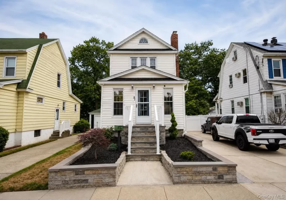 White siding exterior featuring a gabled roofline White siding exterior featuring a gabled roofline