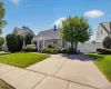Front exterior with a concrete driveway, established landscaping, and a white privacy fence Front exterior with a concrete driveway, established landscaping, and a white privacy fence