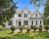 Elegant Colonial-style residence showcasing white vinyl siding, multi-gabled roofline, and a welcoming front facade. Elegant Colonial-style residence showcasing white vinyl siding, multi-gabled roofline, and a welcoming front facade.