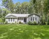Ranch-style residence featuring grey siding, a dark entry door, and white window trim Ranch-style residence featuring grey siding, a dark entry door, and white window trim