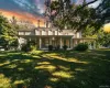 View of front of home featuring a porch, a chimney, and a lawn View of front of home featuring a porch, a chimney, and a lawn