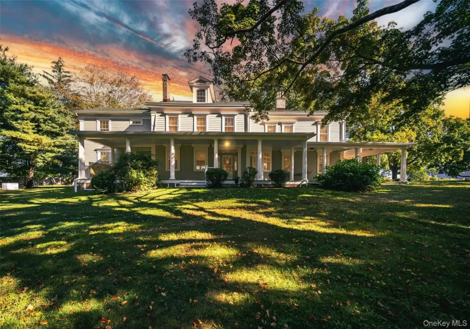 View of front of home featuring a porch, a chimney, and a lawn View of front of home featuring a porch, a chimney, and a lawn