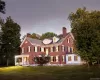 Back of property featuring a chimney, brick siding, and a lawn Back of property featuring a chimney, brick siding, and a lawn