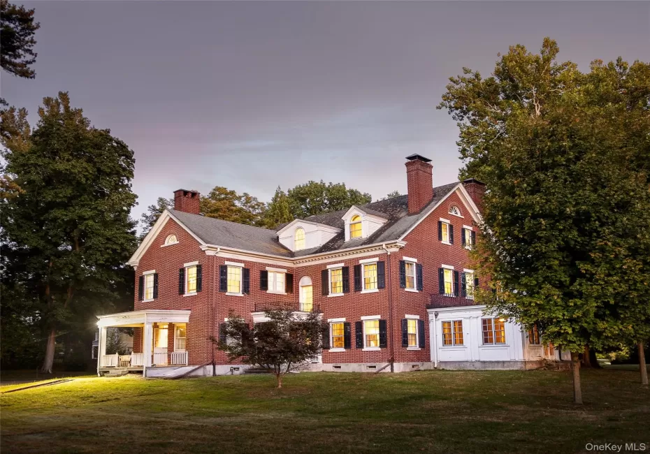 Back of property featuring a chimney, brick siding, and a lawn Back of property featuring a chimney, brick siding, and a lawn