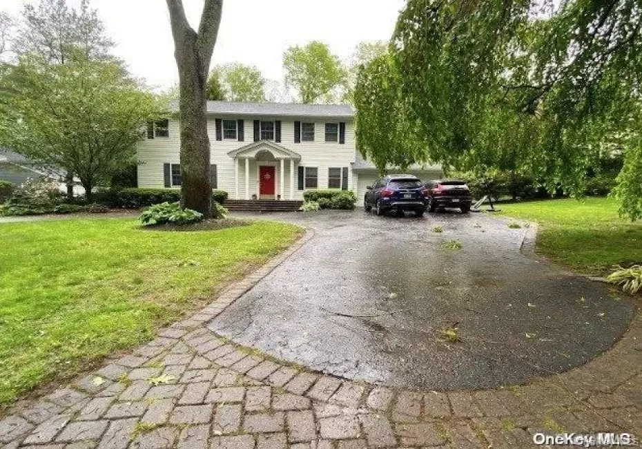 Colonial inspired home featuring asphalt driveway and a front yard Colonial inspired home featuring asphalt driveway and a front yard