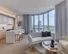 Living area featuring plenty of natural light, light wood-type flooring, a view of city, and expansive windows Living area featuring plenty of natural light, light wood-type flooring, a view of city, and expansive windows