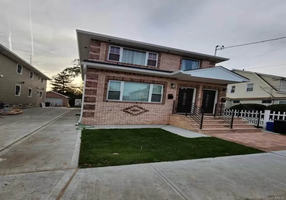 Brick facade with decorative banding, dual entryways, concrete driveway, and paved front walkway Brick facade with decorative banding, dual entryways, concrete driveway, and paved front walkway