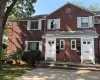 Brick facade featuring white paneled shutters, white entry doors, and twin exterior wall lanterns Brick facade featuring white paneled shutters, white entry doors, and twin exterior wall lanterns