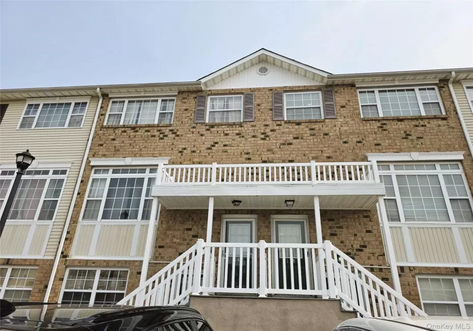 Brick facade, white railings, shuttered windows, gabled roofline, and bay windows Brick facade, white railings, shuttered windows, gabled roofline, and bay windows