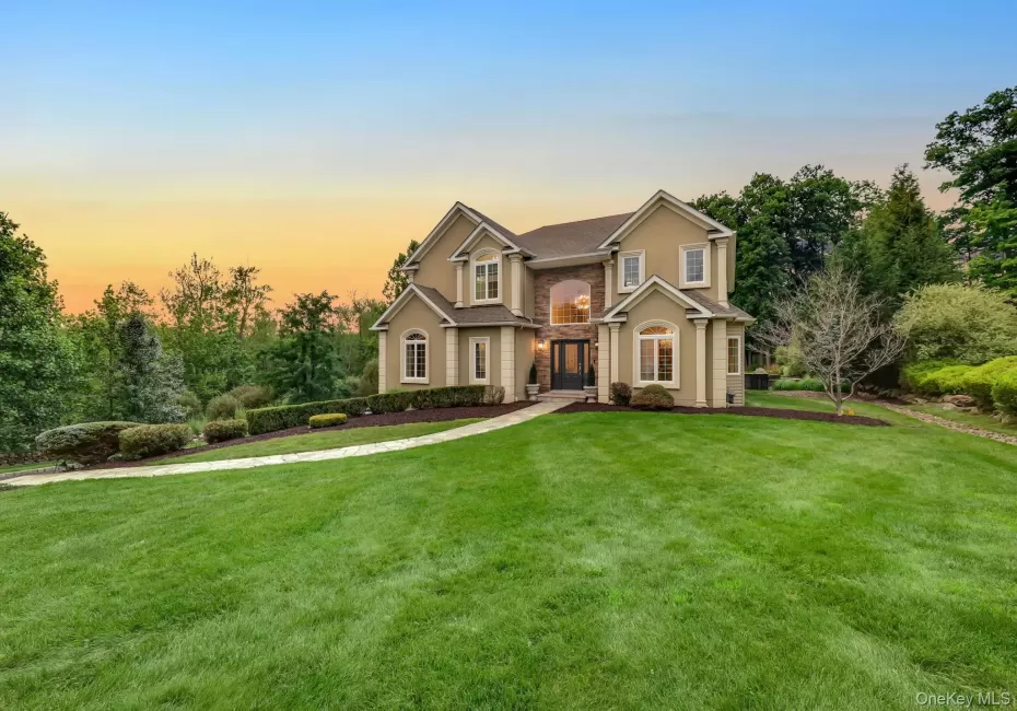 Stucco exterior with stone accents, arched entryway, bay windows, and a paved walkway Stucco exterior with stone accents, arched entryway, bay windows, and a paved walkway