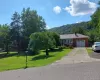 Ranch-style house featuring a front yard, asphalt driveway, a chimney, an attached garage, and brick siding Ranch-style house featuring a front yard, asphalt driveway, a chimney, an attached garage, and brick siding