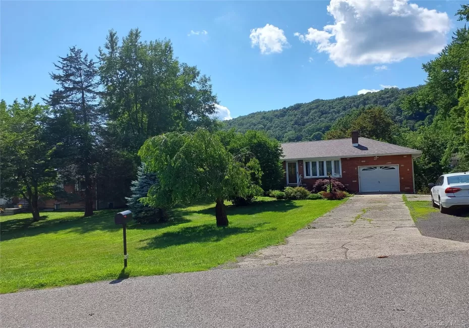 Ranch-style house featuring a front yard, asphalt driveway, a chimney, an attached garage, and brick siding Ranch-style house featuring a front yard, asphalt driveway, a chimney, an attached garage, and brick siding