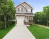 View of front of home with concrete driveway, a front lawn, an attached garage, stone siding, and a porch View of front of home with concrete driveway, a front lawn, an attached garage, stone siding, and a porch