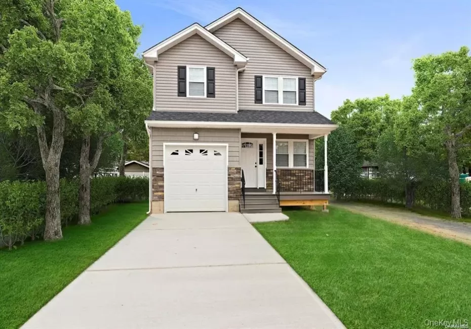 View of front of home with concrete driveway, a front lawn, an attached garage, stone siding, and a porch View of front of home with concrete driveway, a front lawn, an attached garage, stone siding, and a porch