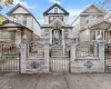 Victorian house with a gate, a fenced front yard, and brick siding Victorian house with a gate, a fenced front yard, and brick siding