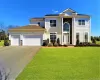 Contemporary Colonial-style residence featuring a prominent portico entrance with substantial white columns and a stone-clad facade Contemporary Colonial-style residence featuring a prominent portico entrance with substantial white columns and a stone-clad facade