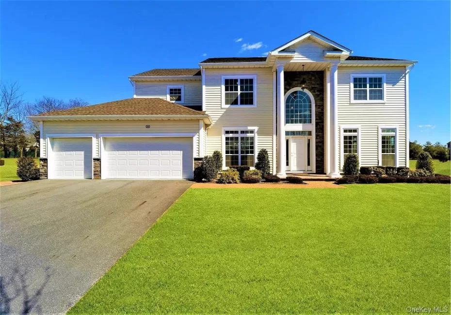 Contemporary Colonial-style residence featuring a prominent portico entrance with substantial white columns and a stone-clad facade Contemporary Colonial-style residence featuring a prominent portico entrance with substantial white columns and a stone-clad facade