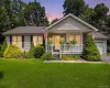 Siding exterior with a covered front porch featuring white railings, an attached garage, and a lush green lawn Siding exterior with a covered front porch featuring white railings, an attached garage, and a lush green lawn