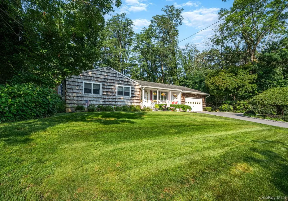 Single-story residence featuring shingle siding and a white garage door Single-story residence featuring shingle siding and a white garage door