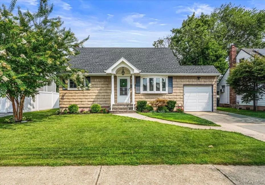 Front exterior featuring shingle siding, an attached garage, a bay window, and a covered entry Front exterior featuring shingle siding, an attached garage, a bay window, and a covered entry
