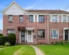 Brick facade with multiple window styles, two awnings, and a concrete pathway Brick facade with multiple window styles, two awnings, and a concrete pathway