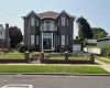 Brick exterior featuring a Juliet balcony with metal railing, arched windows, and full glass entryway with double doors. Fenced in yard with brick and metal railings and metal gates. Fully landscaped yard. Brick exterior featuring a Juliet balcony with metal railing, arched windows, and full glass entryway with double doors. Fenced in yard with brick and metal railings and metal gates. Fully landscaped yard.