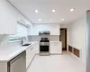 Kitchen featuring white glossy cabinetry, stainless steel appliances, recessed lighting, and white tile flooring Kitchen featuring white glossy cabinetry, stainless steel appliances, recessed lighting, and white tile flooring