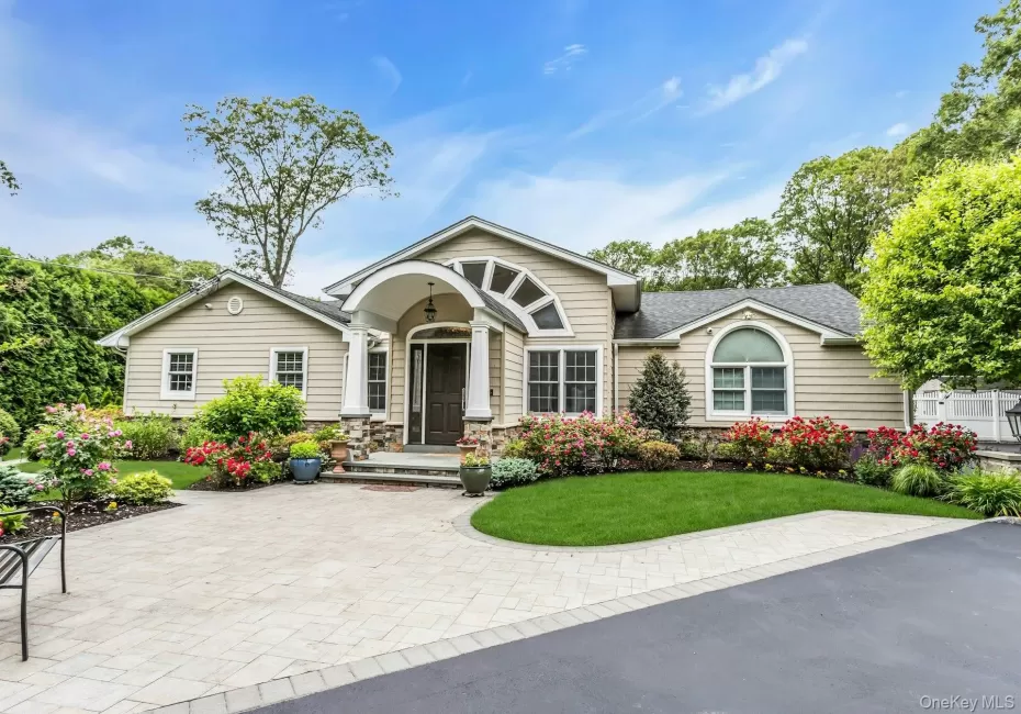 View of front of home with a front yard, roof with shingles, and stone siding View of front of home with a front yard, roof with shingles, and stone siding