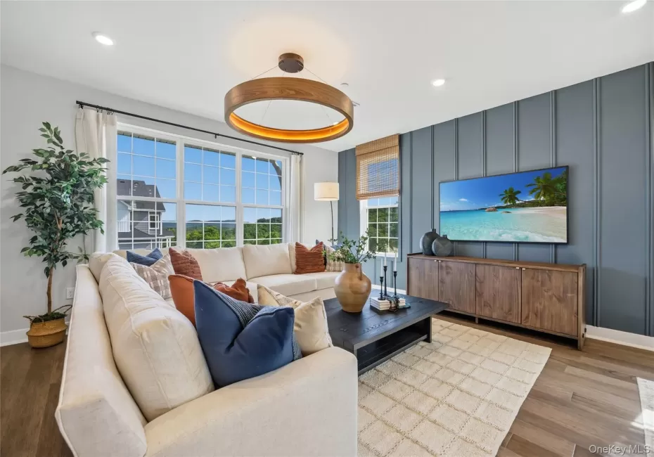Spacious living area featuring large windows with wood-finish flooring. Spacious living area featuring large windows with wood-finish flooring.