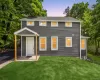 Exterior featuring dark grey horizontal siding, white trim windows, and a covered front entry with natural wood posts Exterior featuring dark grey horizontal siding, white trim windows, and a covered front entry with natural wood posts