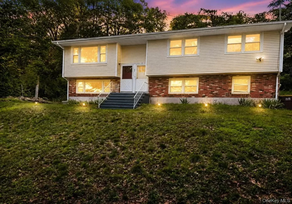 Split-level residence featuring a brick and siding exterior, multiple windows, and exterior steps with handrails Split-level residence featuring a brick and siding exterior, multiple windows, and exterior steps with handrails