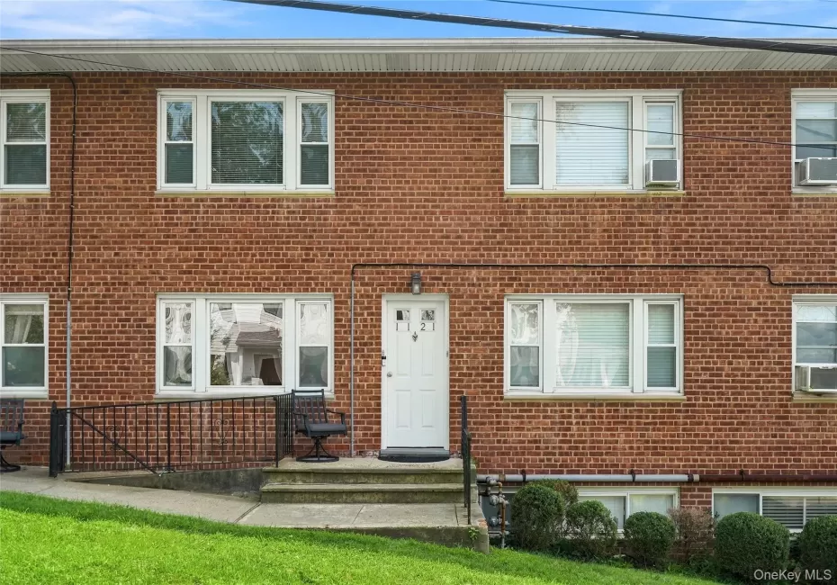 Inviting brick exterior with sun-drenched multi-pane windows and a covered entry stoop Inviting brick exterior with sun-drenched multi-pane windows and a covered entry stoop