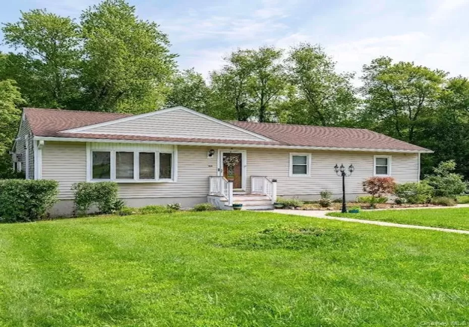 Single-story residence featuring light-colored siding, a bay window, and a concrete pathway leading to the front entry Single-story residence featuring light-colored siding, a bay window, and a concrete pathway leading to the front entry