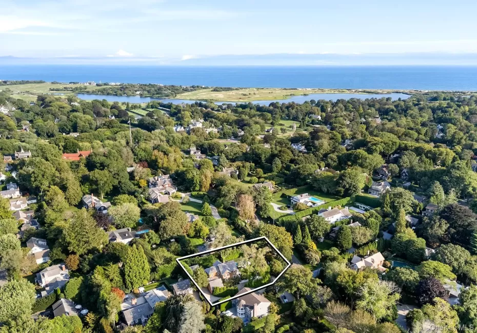 Aerial view of residential area with property boundaries highlighted and a nearby body of water Aerial view of residential area with property boundaries highlighted and a nearby body of water