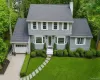 Colonial-style residence featuring a gray shingle exterior, bay windows, and a gray shingle roof Colonial-style residence featuring a gray shingle exterior, bay windows, and a gray shingle roof