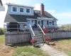 Rear view of house featuring a wooden deck, roof with shingles, a chimney, and stairs Rear view of house featuring a wooden deck, roof with shingles, a chimney, and stairs