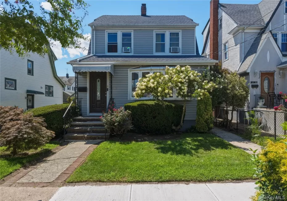 Traditional two-story residence with gray siding and a dark shingled roof. Large Bay window . Traditional two-story residence with gray siding and a dark shingled roof. Large Bay window .