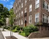 Brick exterior featuring multiple windows, established landscaping, and a sidewalk Brick exterior featuring multiple windows, established landscaping, and a sidewalk