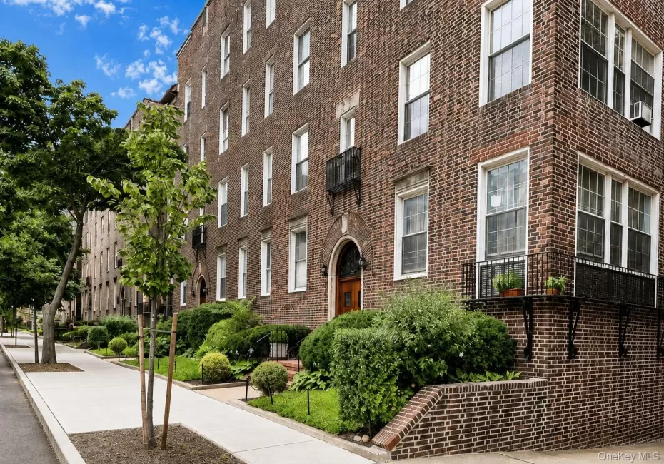 Brick exterior featuring multiple windows, established landscaping, and a sidewalk Brick exterior featuring multiple windows, established landscaping, and a sidewalk