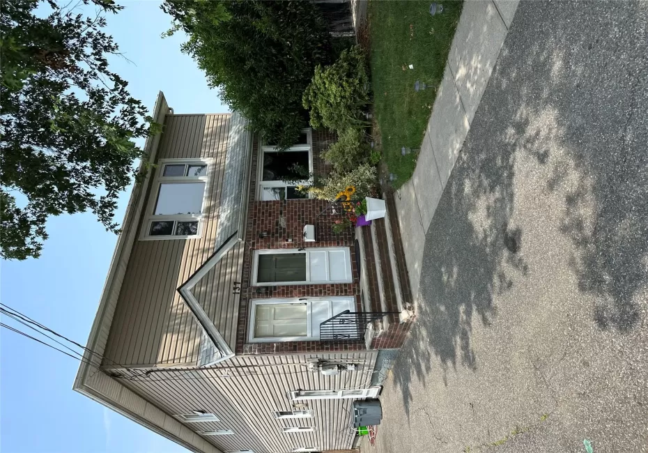 Two-story residence featuring brick and siding exterior, a paved driveway, and a concrete walkway Two-story residence featuring brick and siding exterior, a paved driveway, and a concrete walkway