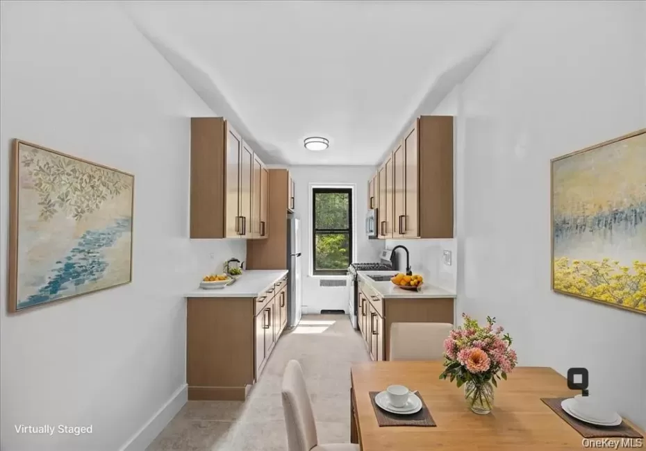 Sleek kitchen featuring wood-finish cabinetry, light-toned countertops, and a stainless steel refrigerator Sleek kitchen featuring wood-finish cabinetry, light-toned countertops, and a stainless steel refrigerator