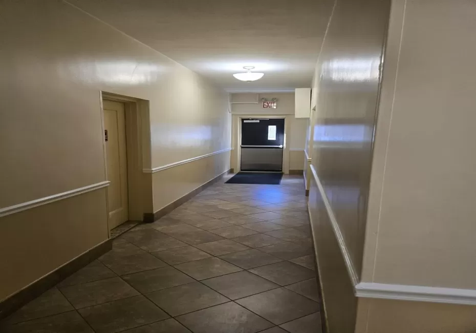 Hall with baseboards and dark tile patterned flooring Hall with baseboards and dark tile patterned flooring