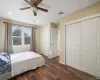 Bedroom with ceiling fan, dark hardwood / wood-style floors, and two closets Bedroom with ceiling fan, dark hardwood / wood-style floors, and two closets