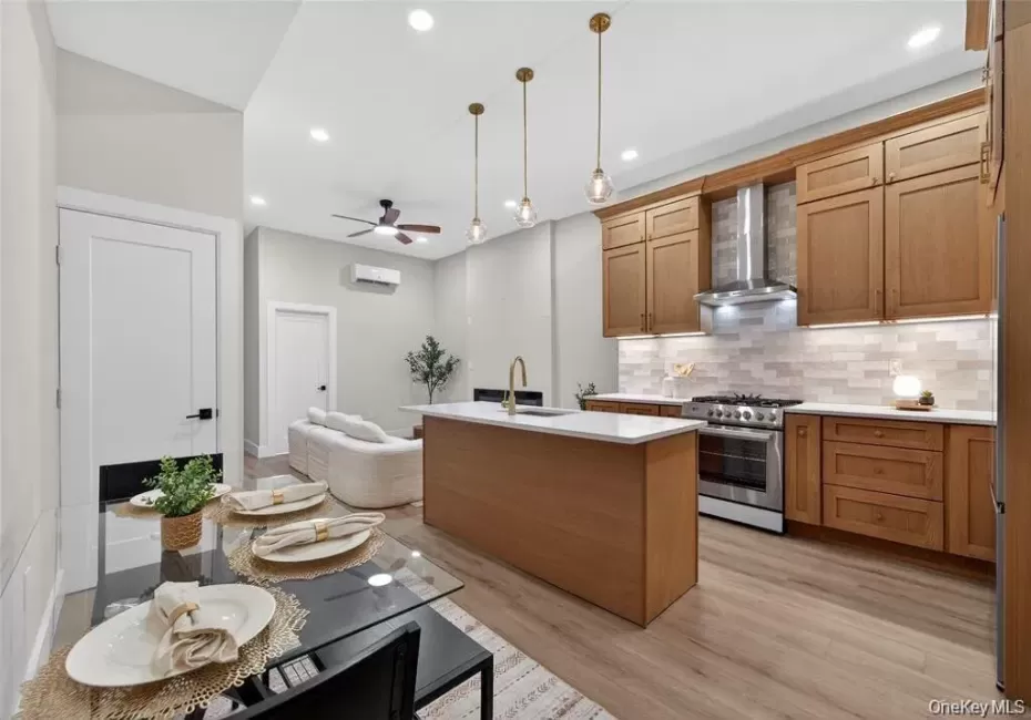 Spacious kitchen featuring wood cabinetry, stainless steel appliances, and a central island with white countertops Spacious kitchen featuring wood cabinetry, stainless steel appliances, and a central island with white countertops