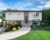 Split-level residence featuring a brick facade, bay window, and a paver pathway Split-level residence featuring a brick facade, bay window, and a paver pathway
