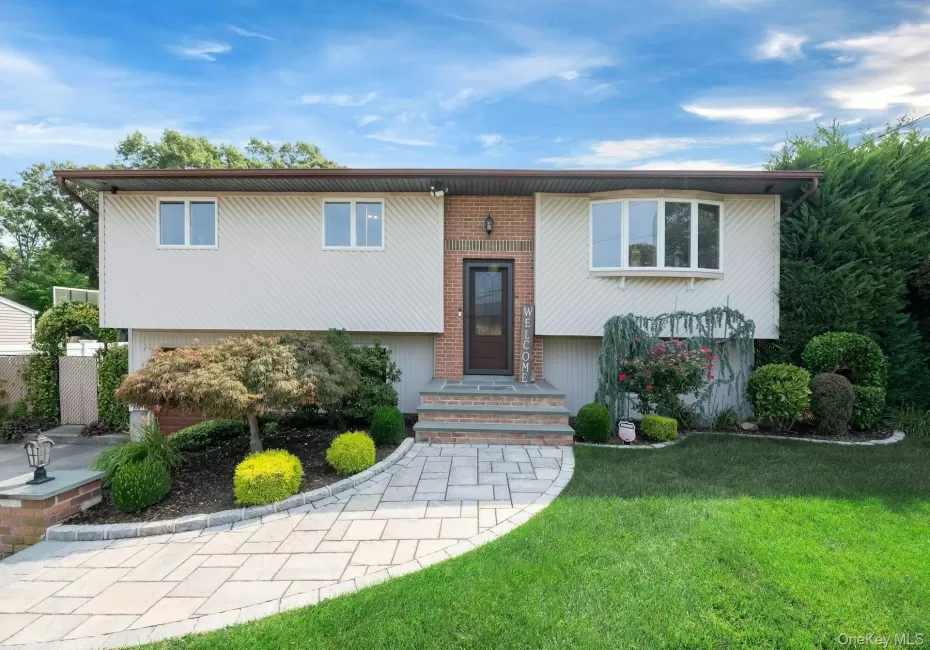 Split-level residence featuring a brick facade, bay window, and a paver pathway Split-level residence featuring a brick facade, bay window, and a paver pathway